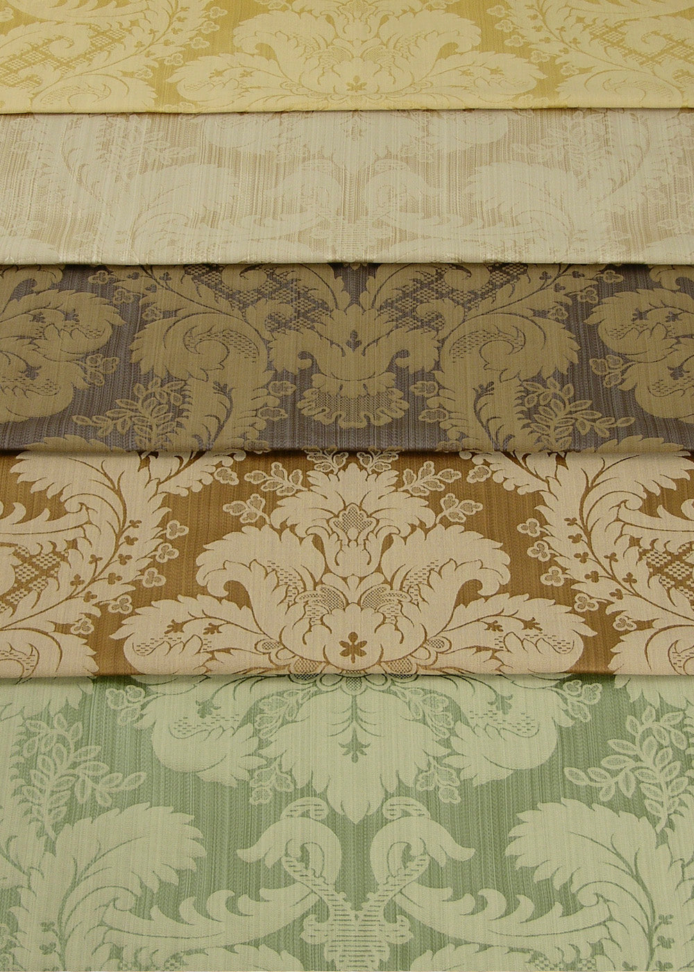 stack of folded silk fabric with a regal damask pattern