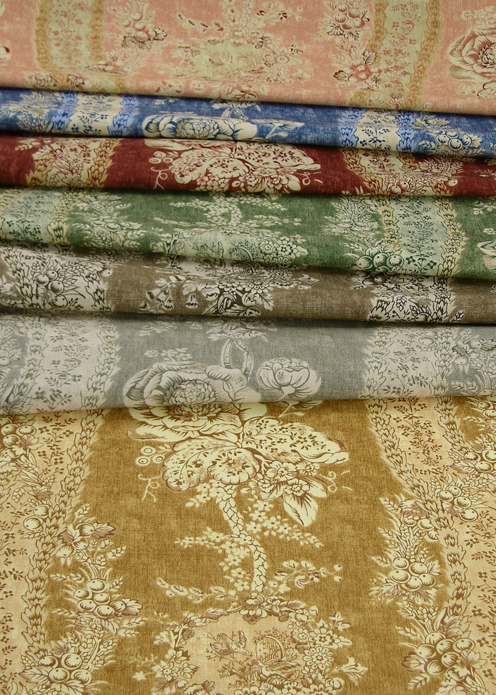 a stack of multicolored fabrics with tonal floral patterns