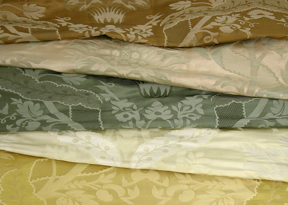 stack of silk fabrics with a woven damask design