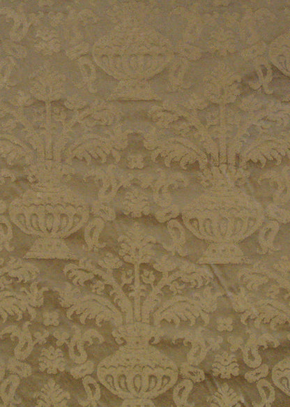 gold fabric with a damask pattern that depicts an abstract vase holding branches