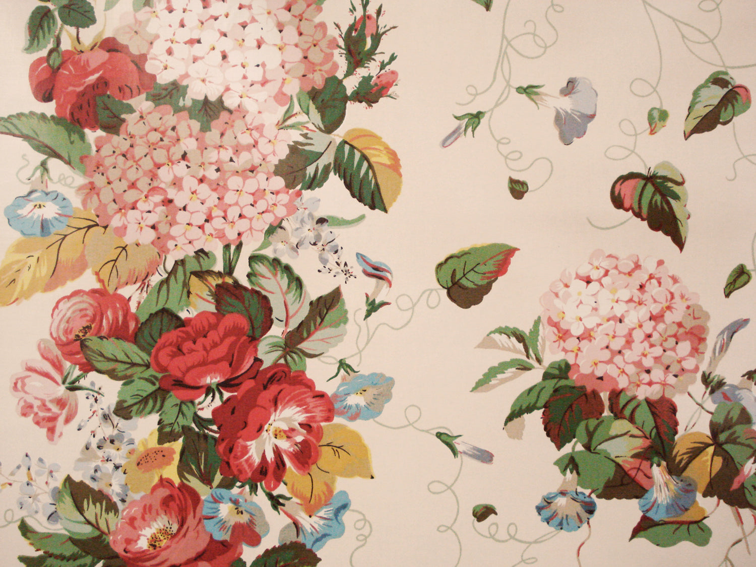 peach fabric printed with bunches of hydrangeas, and a border strip of dense floral print