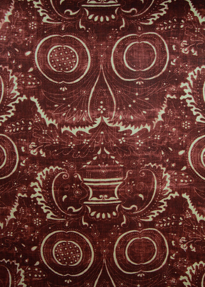 dark red fabric with a swirly printed pattern