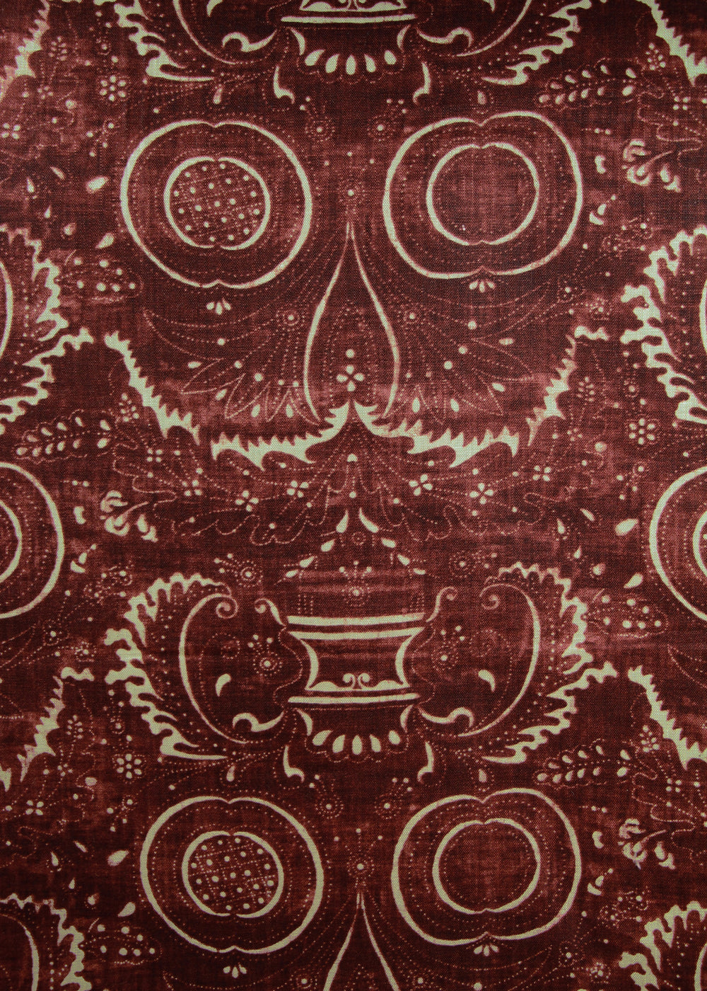 dark red fabric with a swirly printed pattern