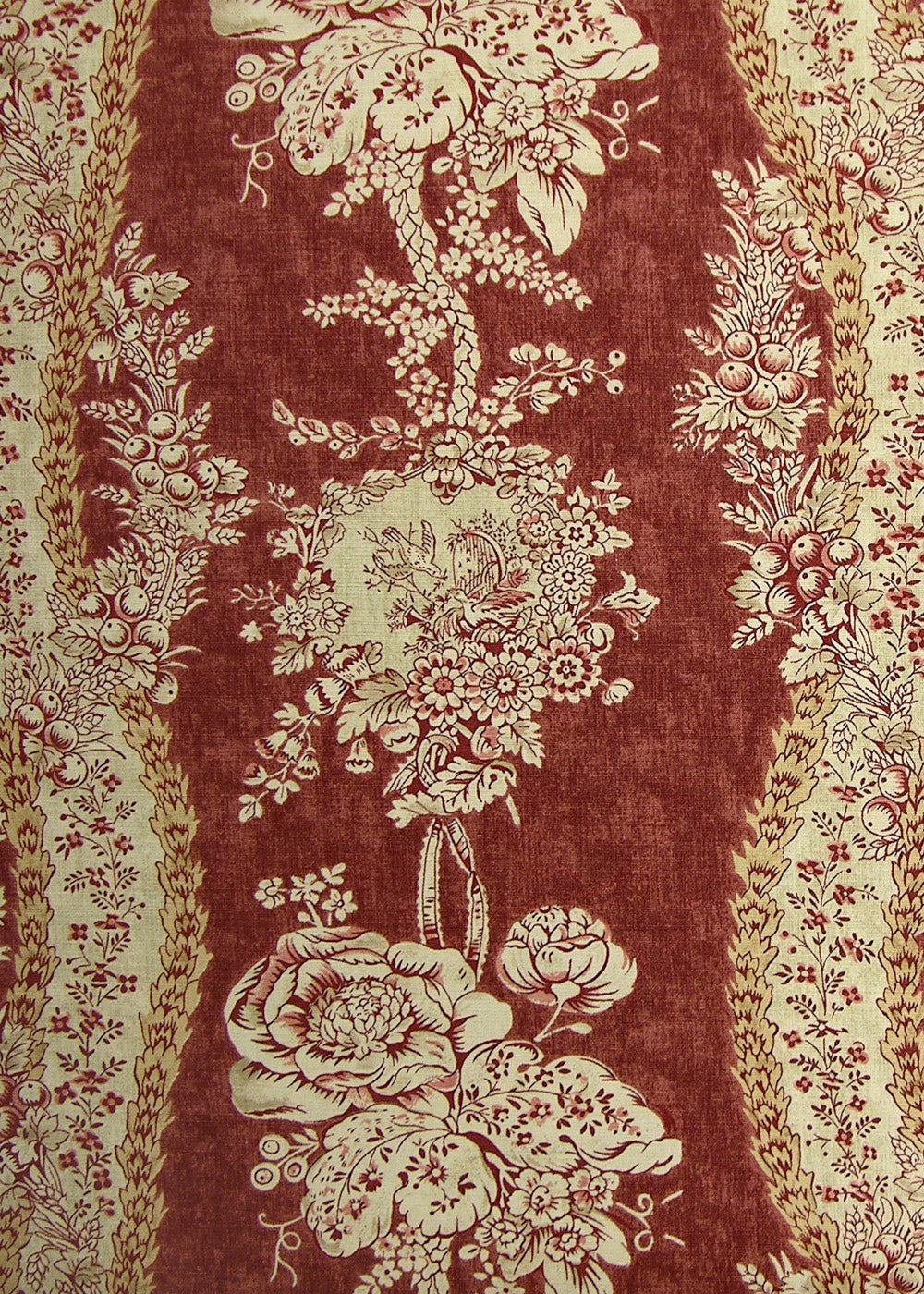 red fabric with a monochromatic pattern of florals, vines, and berries
