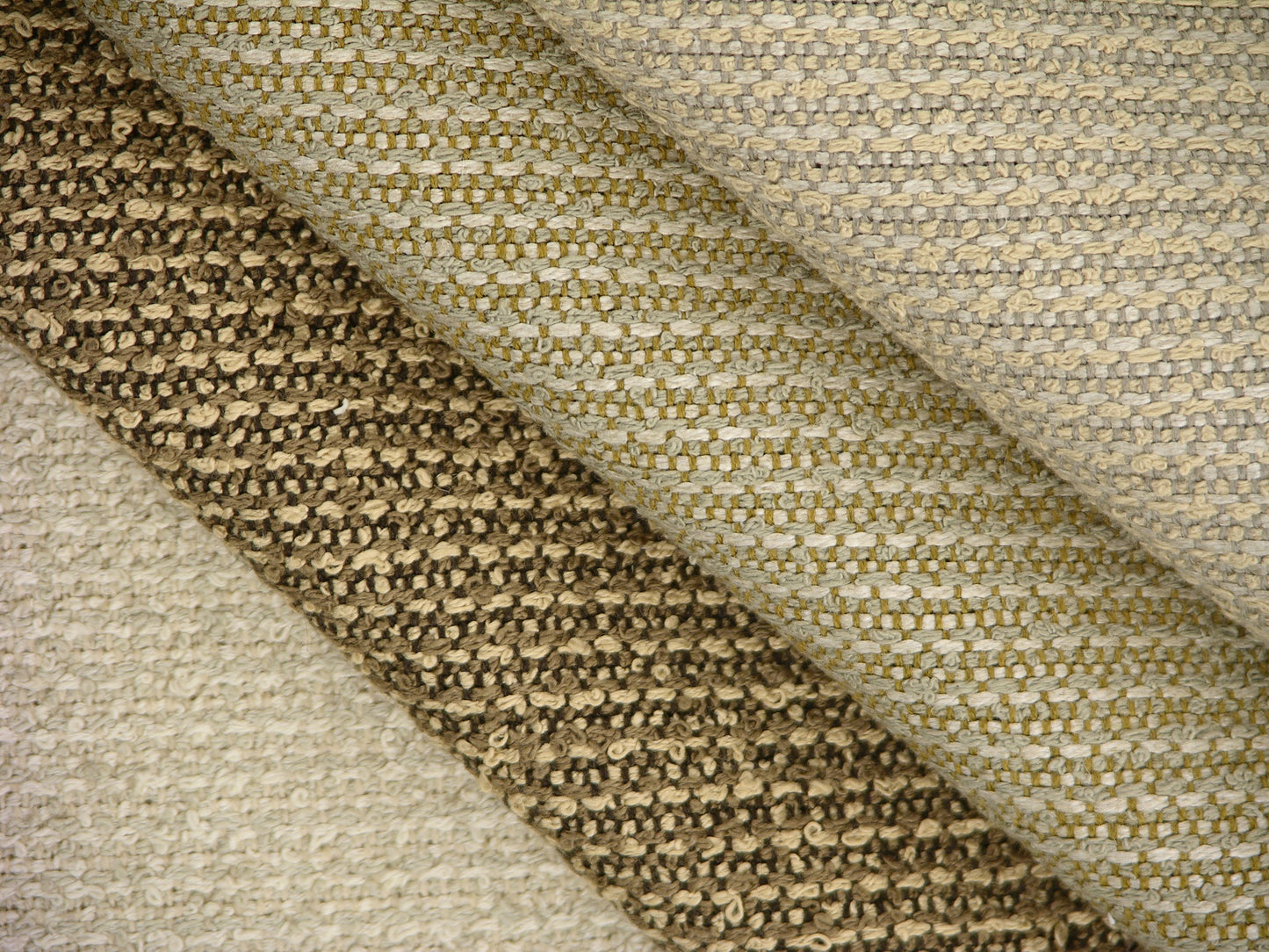 stack of upholstery boucle fabrics in shades of tan