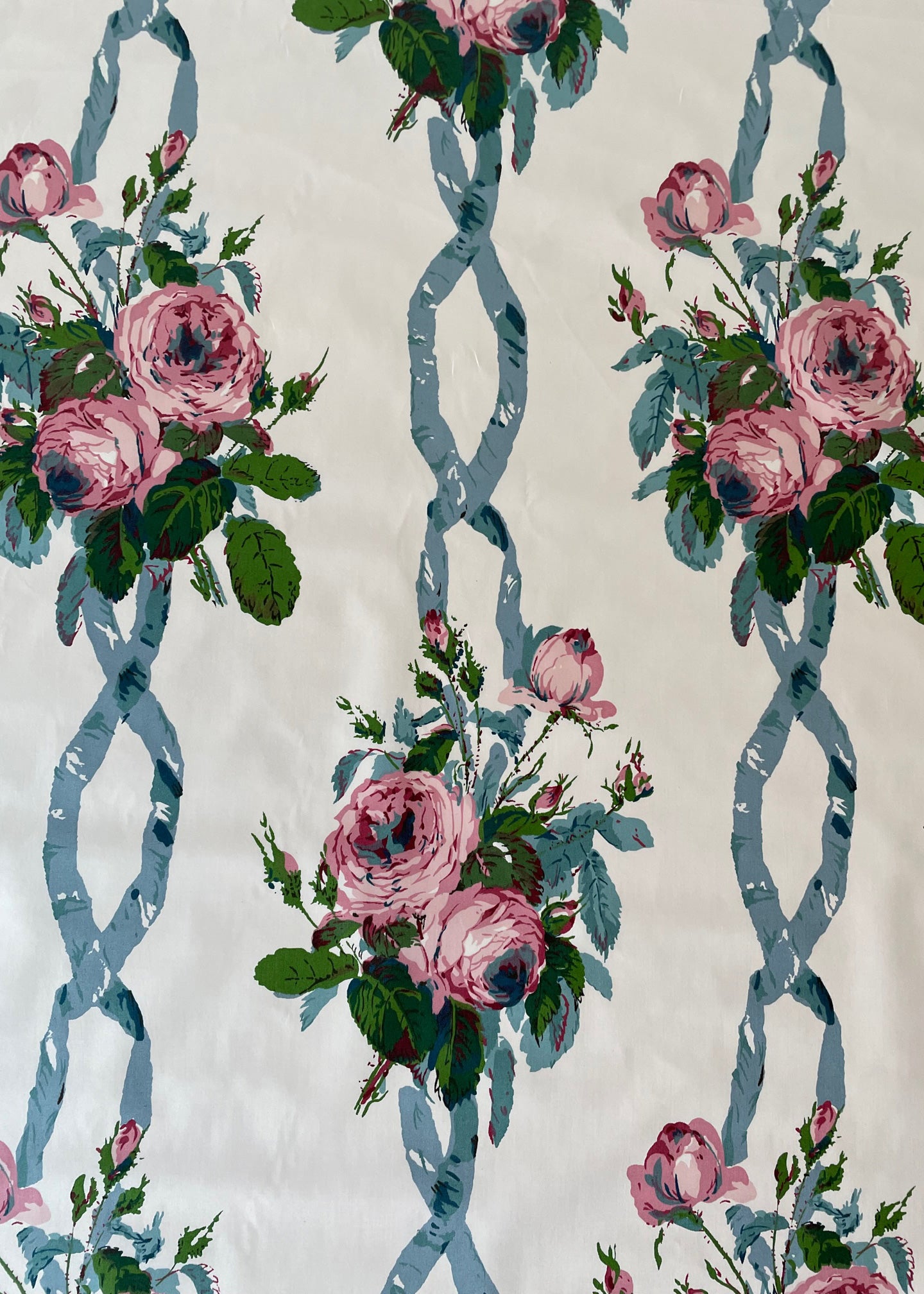 chintz fabric printed with bunches of pink roses and blue ribbons