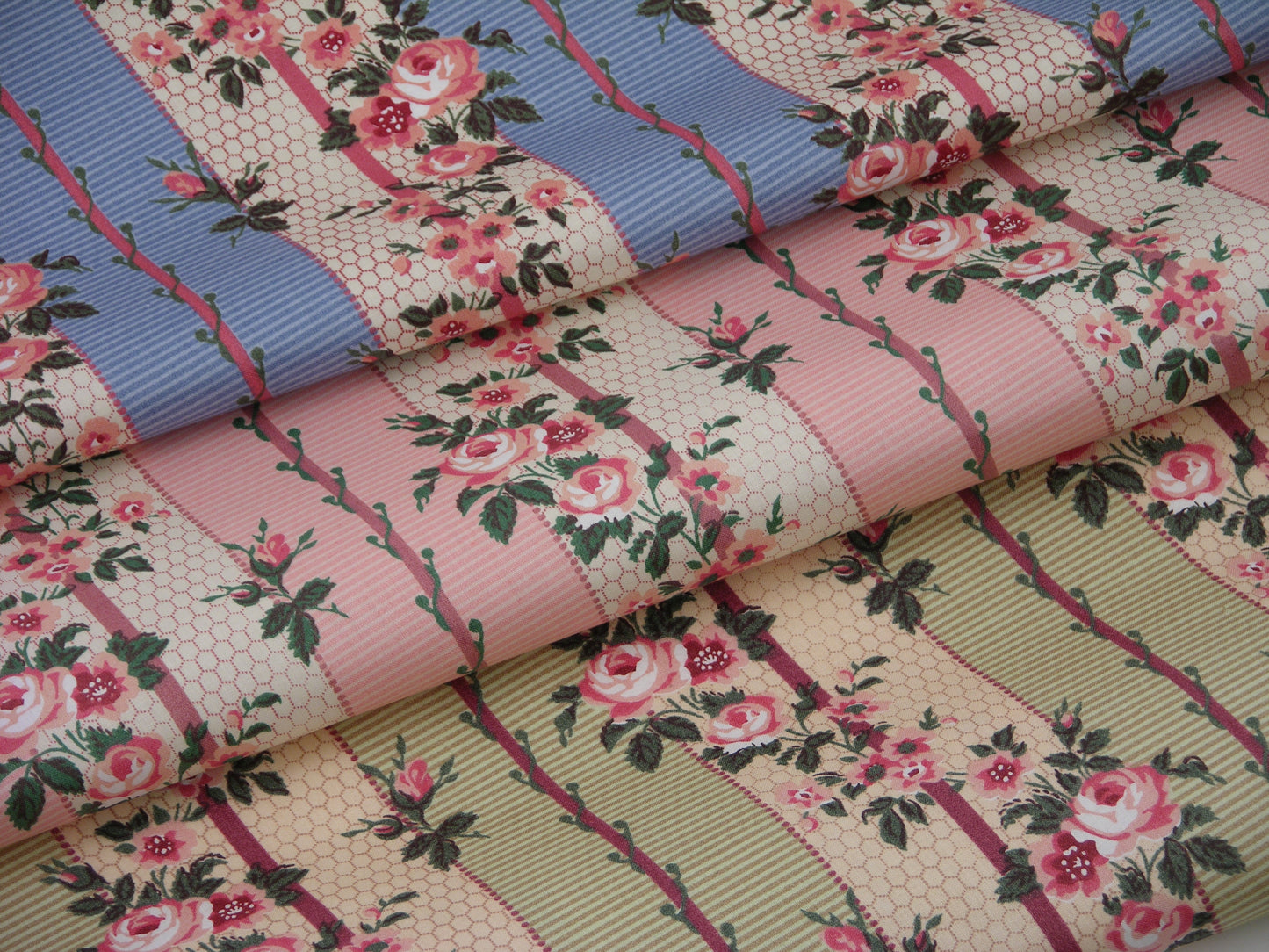 three folded fabrics printed with small-scale stripes and roses