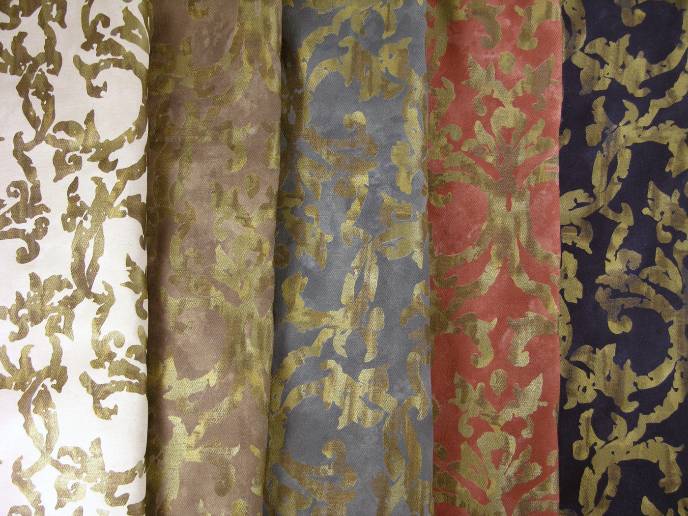 stack of fabrics with metallic gold branching design printed on them