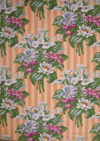 fabric printed with easter lilies on an orange striped background