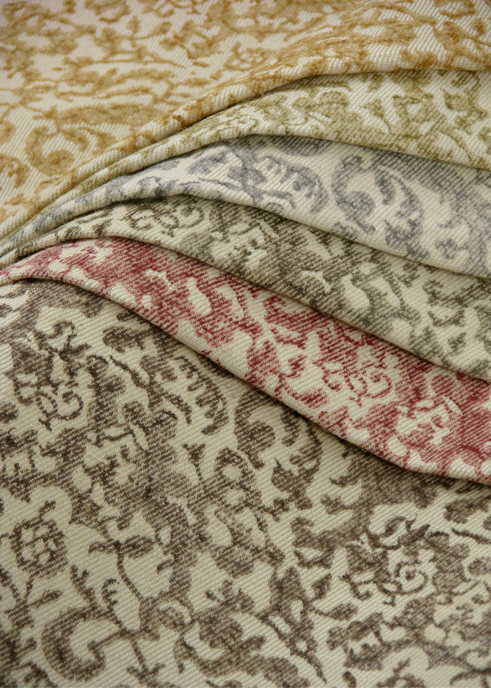 stack of natural colored fabrics with a small-scale floral block print