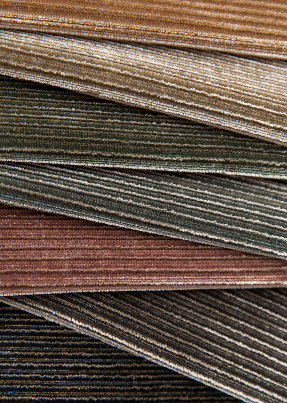 stack of jewel toned velvet fabrics with horizontal ribbed texture