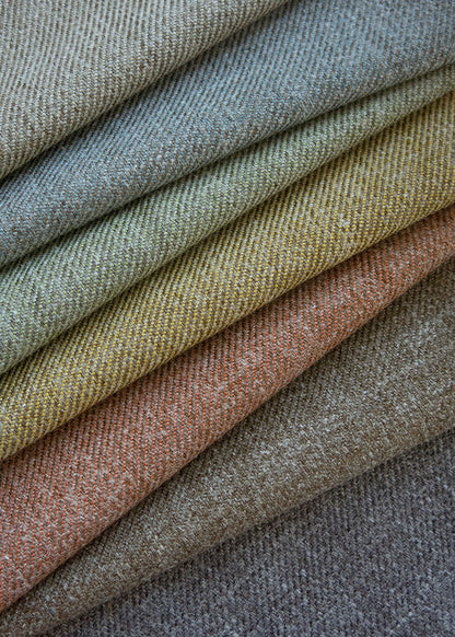 a stack of twill upholstery fabrics in different colors