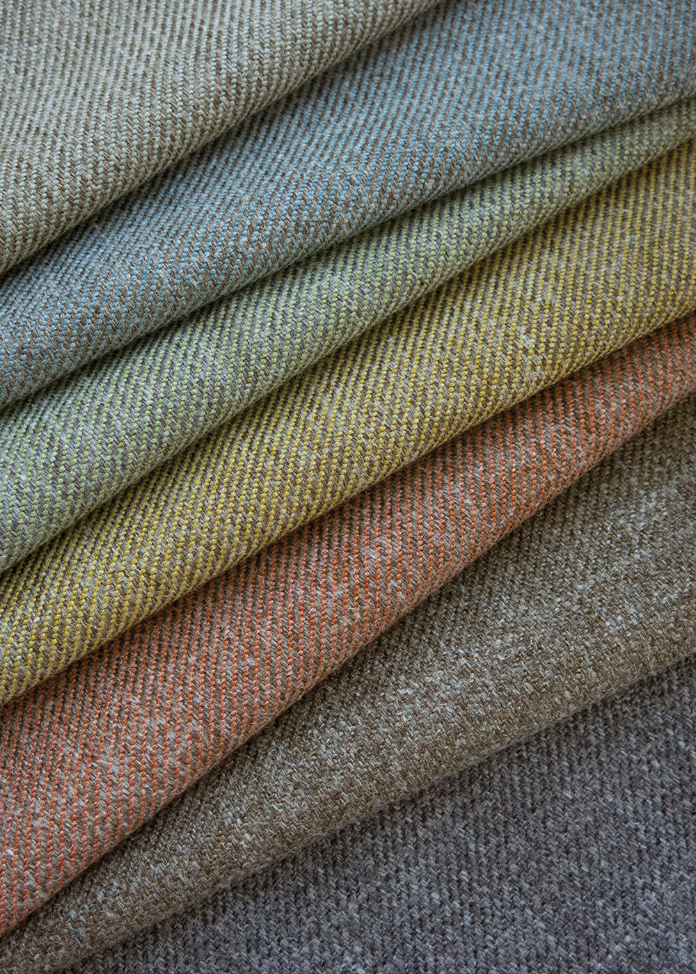 a stack of twill upholstery fabrics in different colors