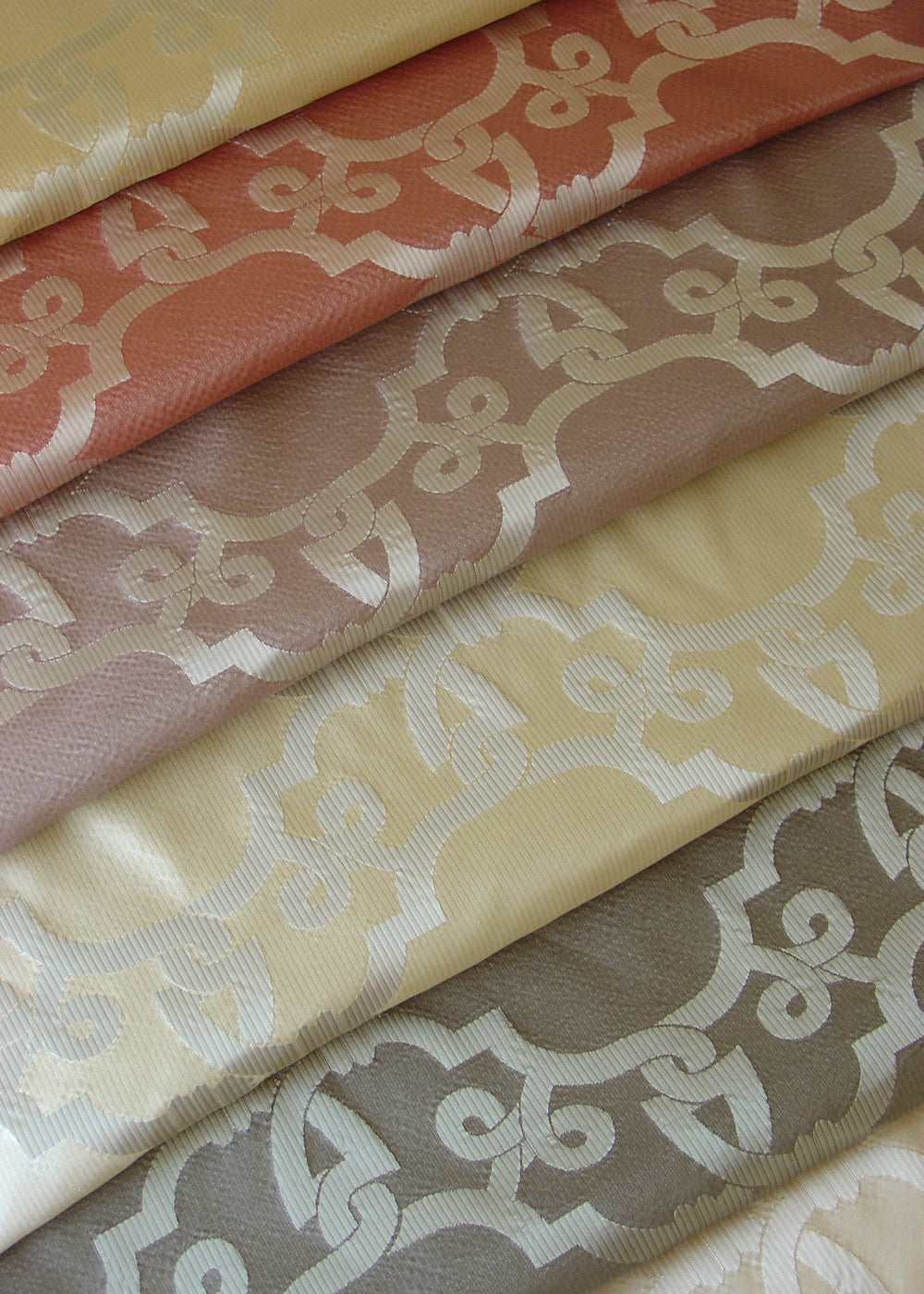 stack of shiny folded fabrics, with a geometric lattice pattern