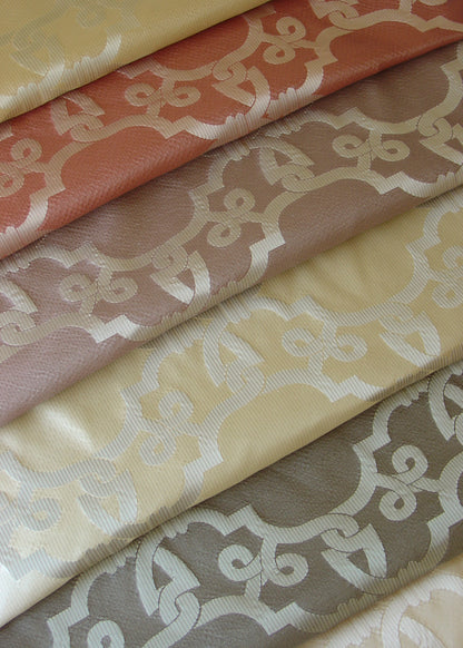 stack of shiny folded fabrics, with a geometric lattice pattern
