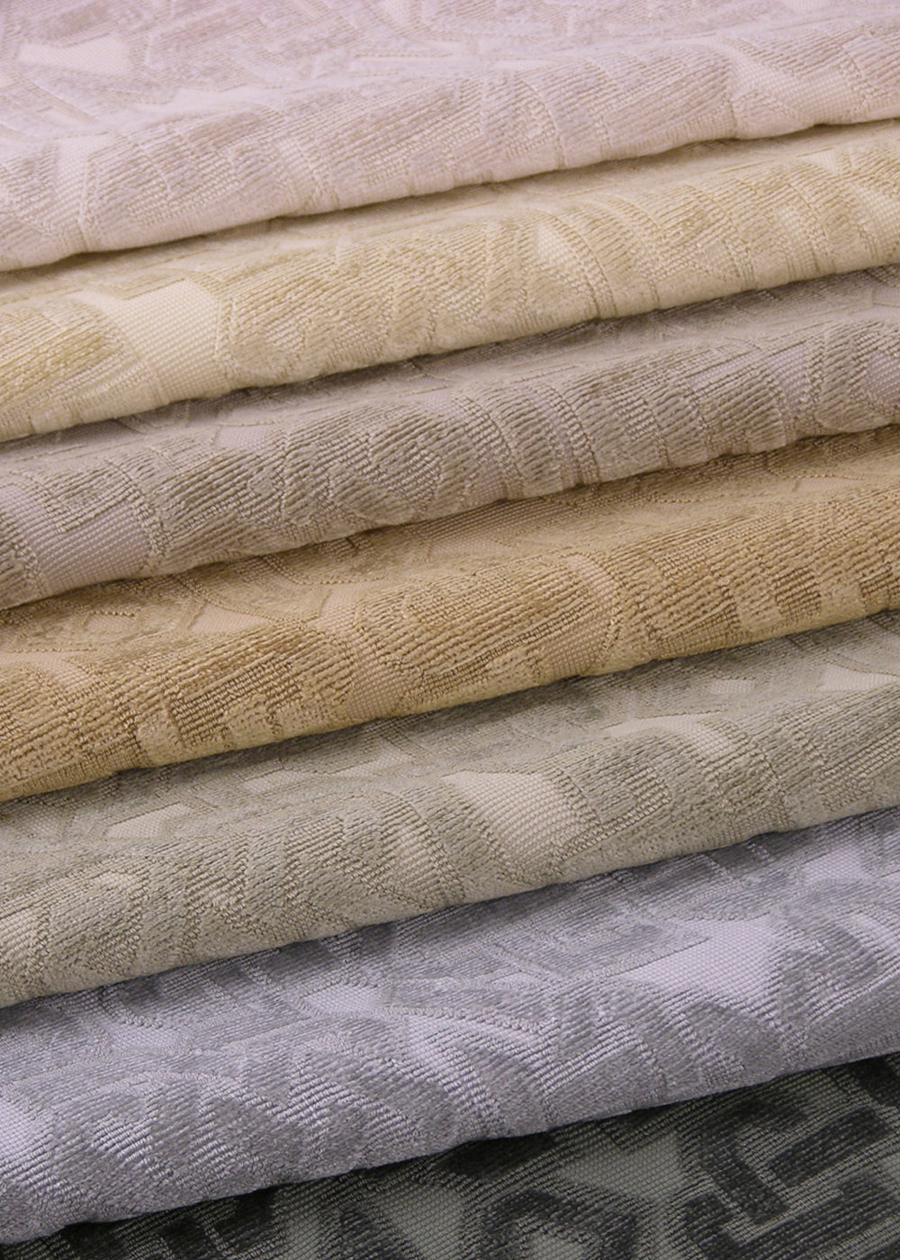 a stack of velvet fabrics with a raised geometric lattice design
