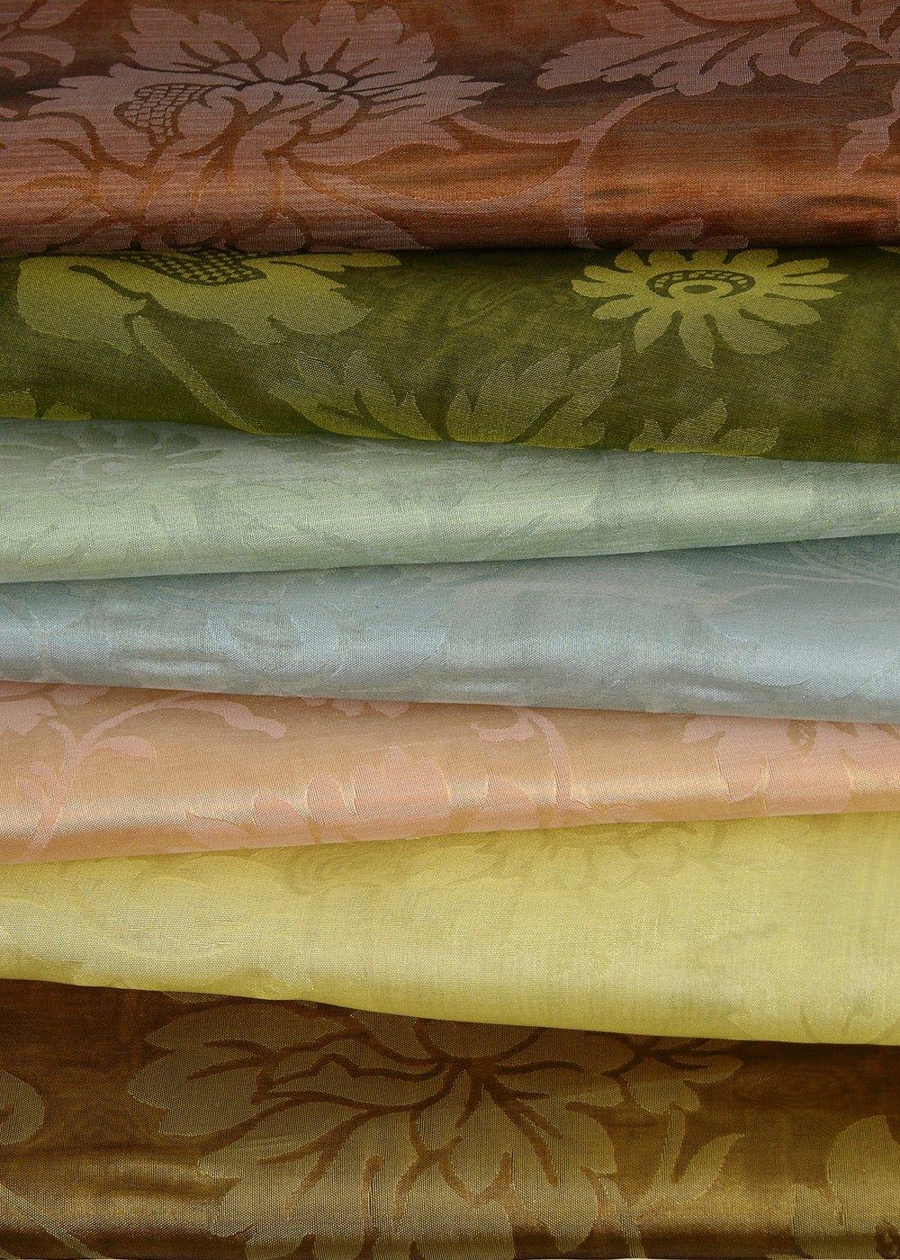 a stack of folded damask fabric with a branching floral design