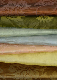 a stack of folded damask fabric with a branching floral design