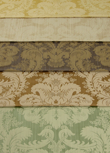 stack of folded silk fabric with a regal damask pattern