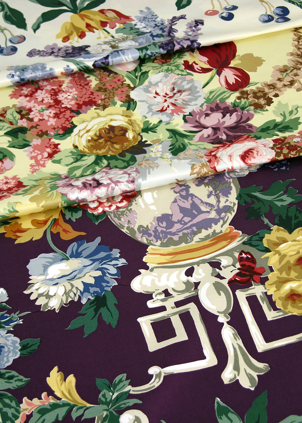 stack of fabrics printed with roses, vases, and geometric scrolls