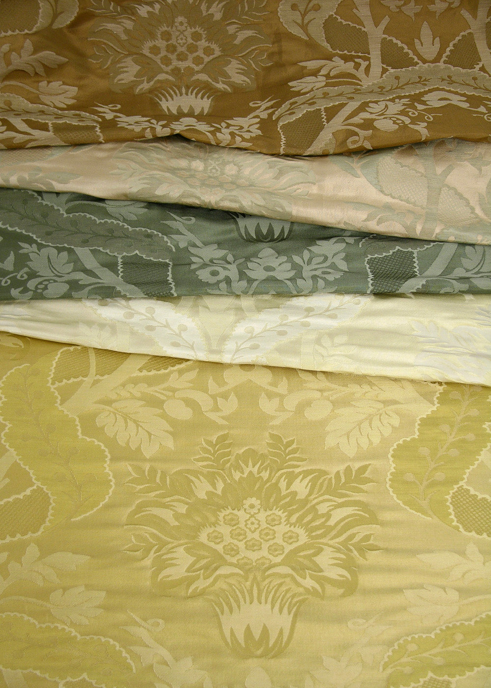 stack of woven damask fabrics in several colors