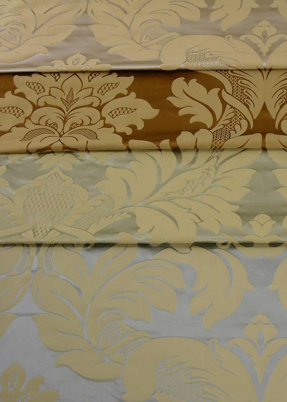 stack of satin damask fabrics in different colors