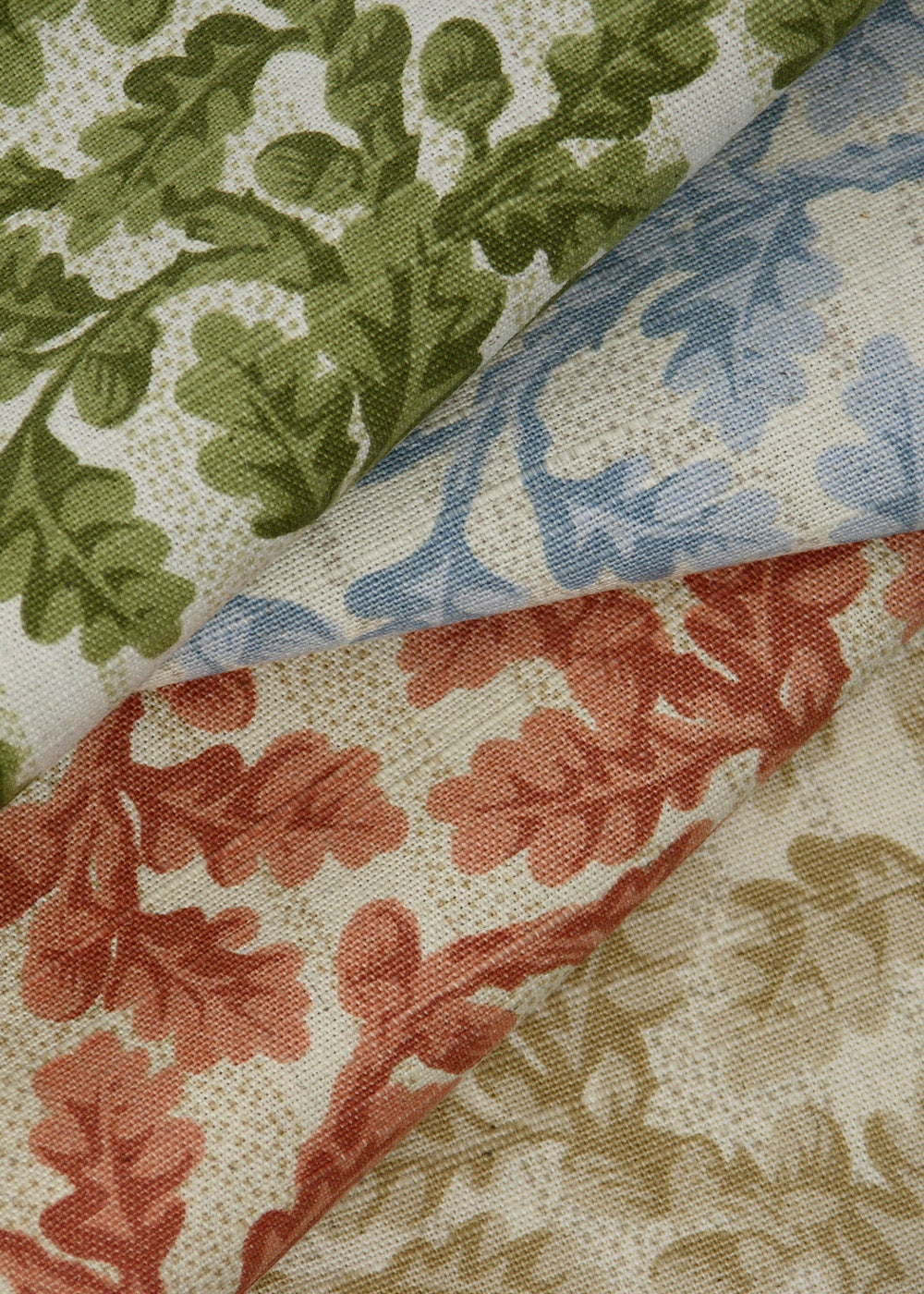 linen fabric printed with small-scale oak leaves and acorns, in several colorways